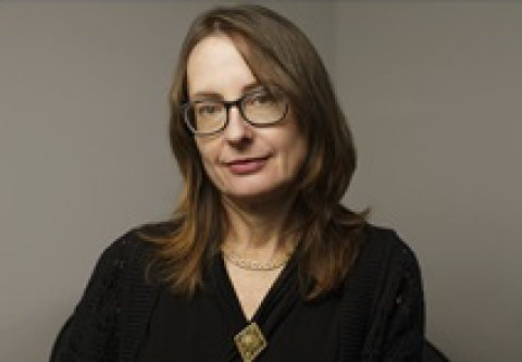 Head shot of Emily Wilson, a white shoulder length brown hair and glasseswoman with