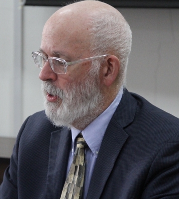  Head shot of Joe Farrell, a white man with glasses and a beard